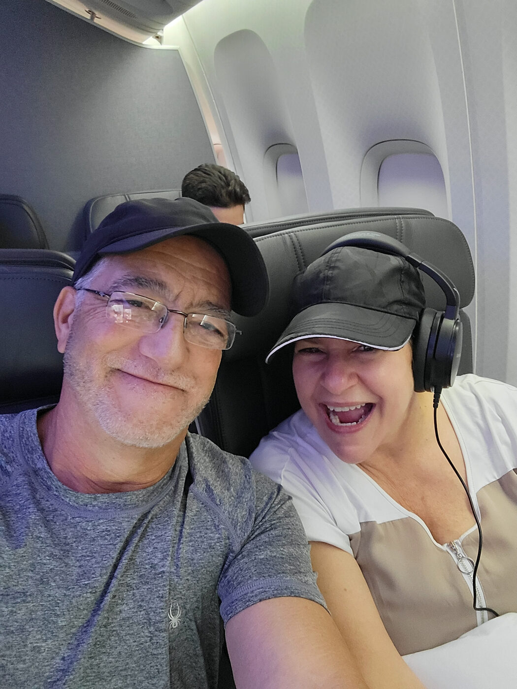 Hector and Bea Hernandez smiling on the plane heading to Europe